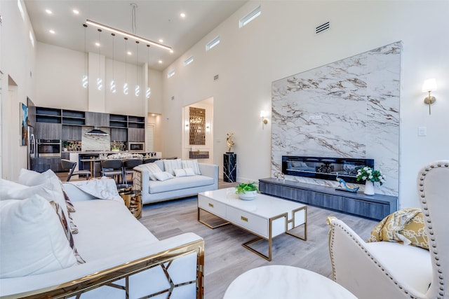 13554 Pyramid Dr, Farmers Branch, TX 75234 - living room with a high end fireplace, a high ceiling, wood finished floors, and recessed lighting