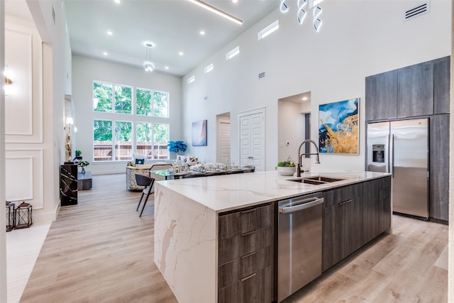 13554 Pyramid Dr, Farmers Branch, TX 75234 - kitchen with appliances with stainless steel finishes, a sink, modern cabinets, a towering ceiling, and a large island with sink