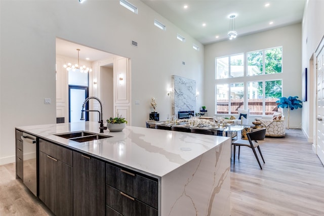 13554 Pyramid Dr, Farmers Branch, TX 75234 - kitchen with a sink, modern cabinets, a large island with sink, a towering ceiling, and light wood-style floors