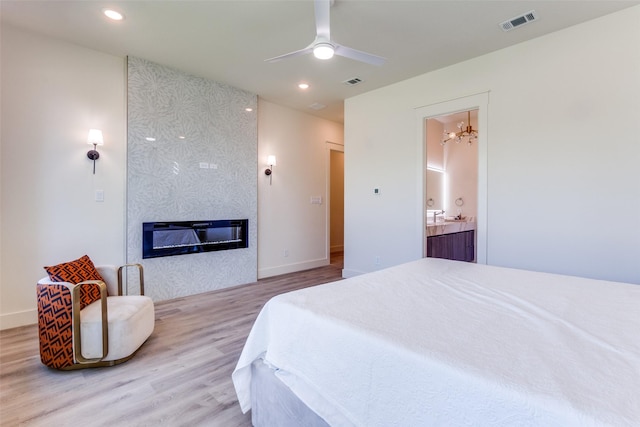 13554 Pyramid Dr, Farmers Branch, TX 75234 - bedroom featuring wood finished floors, a large fireplace, recessed lighting, a chandelier, and baseboards
