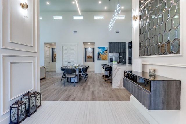 13554 Pyramid Dr, Farmers Branch, TX 75234 - living area with a towering ceiling, light wood-style flooring, and baseboards