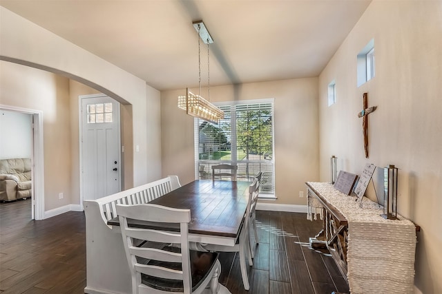 208 Johnson St, Granbury, TX 76048 - dining room featuring arched walkways, dark wood finished floors, and baseboards