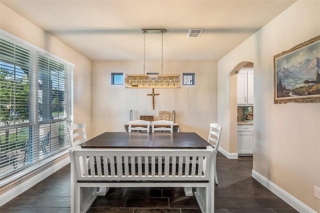 208 Johnson St, Granbury, TX 76048 - dining room featuring arched walkways, baseboards, and dark wood-style floors