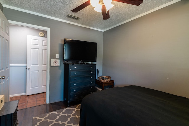 bedroom with a textured ceiling, wood finished floors, and a ceiling fan