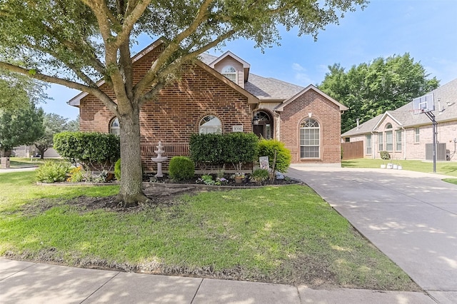 8306 Pecan Creek Dr, Arlington, TX 76001 - view of front of house with brick siding, a front yard, and central air condition unit