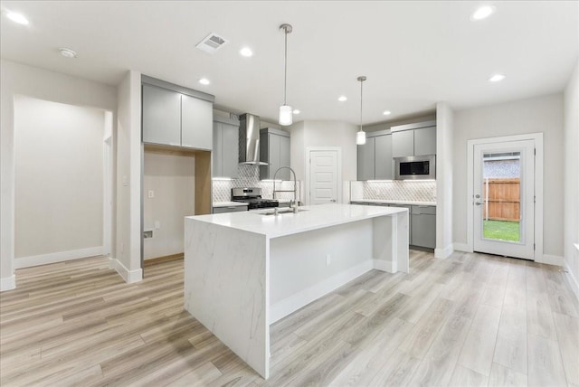 1903 Varsity Dr, Grand Prairie, TX 75051 - kitchen with gray cabinets, wall chimney exhaust hood, appliances with stainless steel finishes, a sink, and recessed lighting