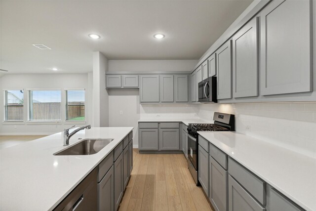 413 Marsh Dr, Lavon, TX 75166 - kitchen with stainless steel appliances, gray cabinetry, a sink, light wood-style floors, and recessed lighting