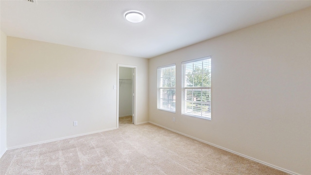 1913 Elk Lake Trl, Fort Worth, TX 76247 - unfurnished bedroom featuring light colored carpet, a spacious closet, baseboards, and a closet