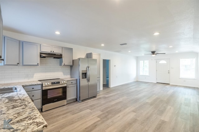 2942 Russell Ave, Abilene, TX 79605 - kitchen with stainless steel appliances, gray cabinets, under cabinet range hood, tasteful backsplash, and light wood finished floors