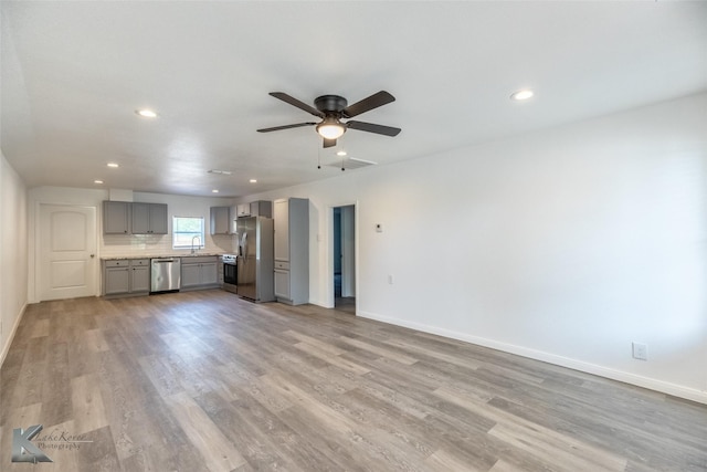 2942 Russell Ave, Abilene, TX 79605 - unfurnished living room with a sink, light wood-style flooring, baseboards, and recessed lighting