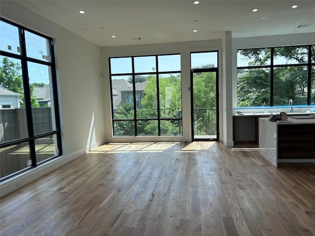 610 N Oak Cliff Blvd Unit 301, Dallas, TX 75208 - unfurnished living room featuring wood finished floors, recessed lighting, baseboards, and a sink