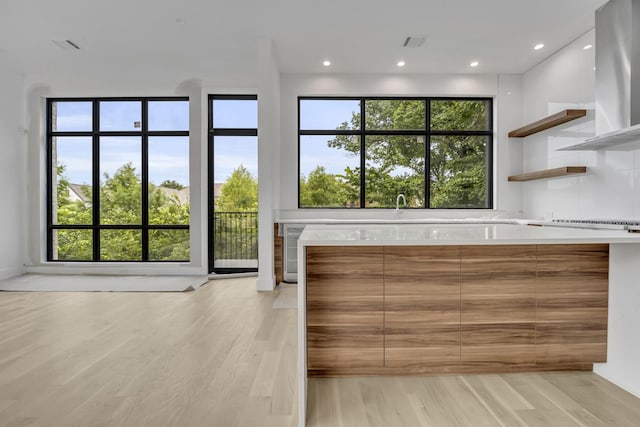 610 N Oak Cliff Blvd Unit 301, Dallas, TX 75208 - kitchen with wall chimney exhaust hood, modern cabinets, light countertops, open shelves, and recessed lighting
