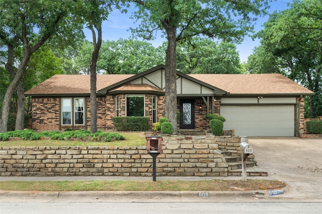 view of front facade featuring an attached garage, concrete driveway, a shingled roof, and brick siding