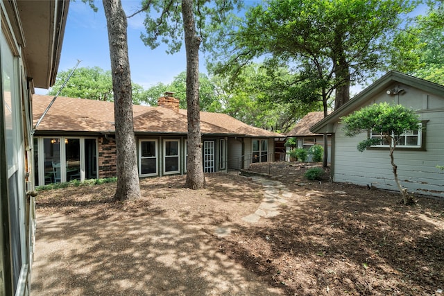 back of property with a chimney