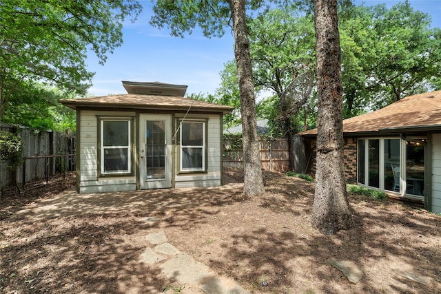 rear view of property with a fenced backyard and an outdoor structure