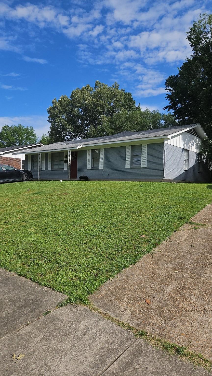 view of front facade featuring brick siding and a front lawn