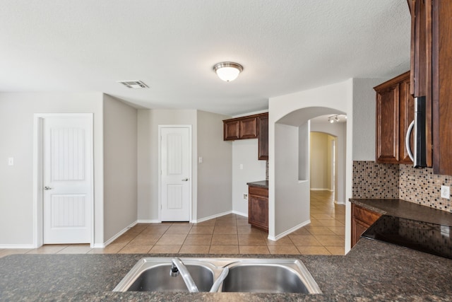 4006 Autumnwood Ln, Heartland, TX 75126 - kitchen with dark countertops, stainless steel microwave, tile patterned floors, and a sink