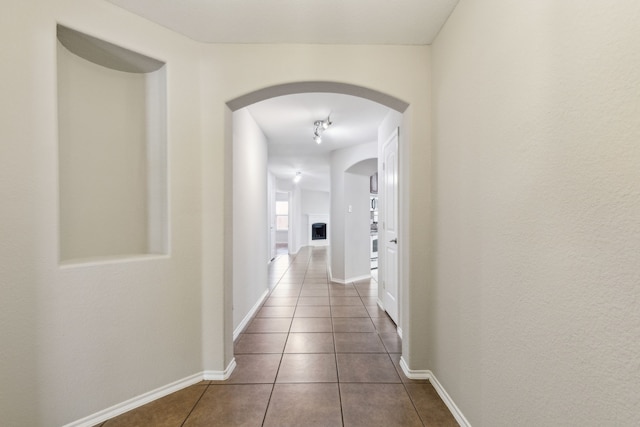 4006 Autumnwood Ln, Heartland, TX 75126 - corridor with arched walkways, dark tile patterned floors, and baseboards
