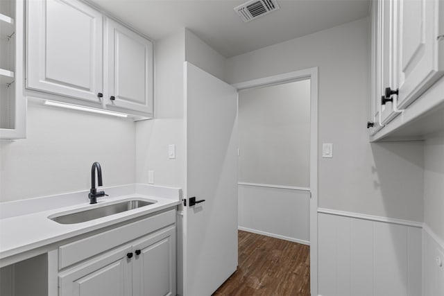 2109 Greta Ln, Fort Worth, TX 76120 - washroom featuring a sink, dark wood finished floors, and a wainscoted wall