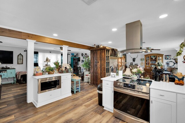 6199 State Highway 22, Hillsboro, TX 76645 - kitchen with stainless steel appliances, a ceiling fan, island range hood, ornate columns, and ornamental molding