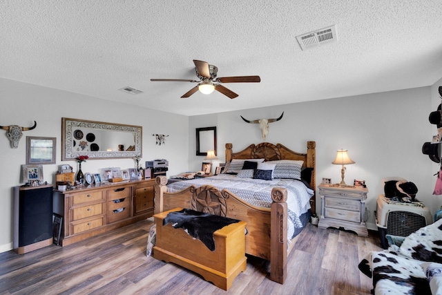 6199 State Highway 22, Hillsboro, TX 76645 - bedroom with wood finished floors, a textured ceiling, a ceiling fan, and baseboards