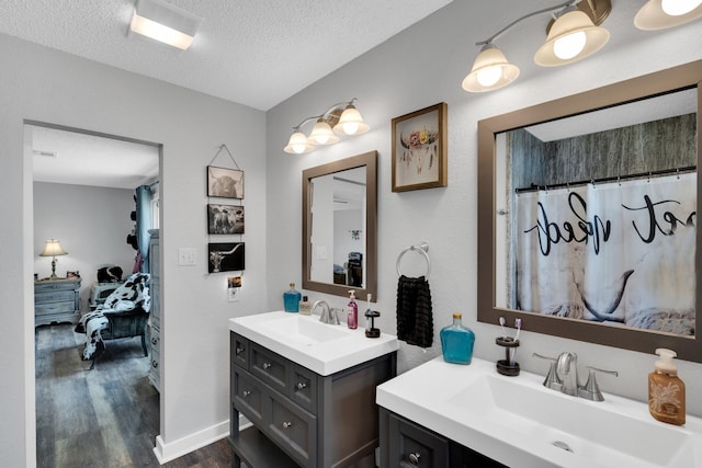 6199 State Highway 22, Hillsboro, TX 76645 - ensuite bathroom with a textured ceiling, wood finished floors, two vanities, and a shower with curtain