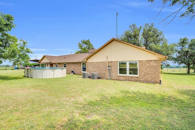 6199 State Highway 22, Hillsboro, TX 76645 - back of house with brick siding, central AC unit, and an outdoor pool
