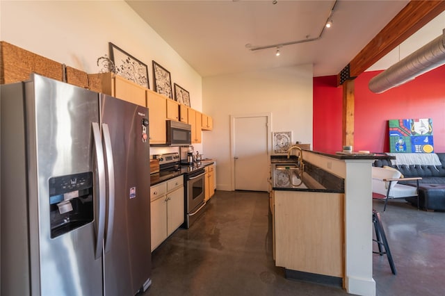 2502 Live Oak St Unit 314, Dallas, TX 75204 - kitchen with appliances with stainless steel finishes, dark countertops, finished concrete floors, a peninsula, and a kitchen breakfast bar