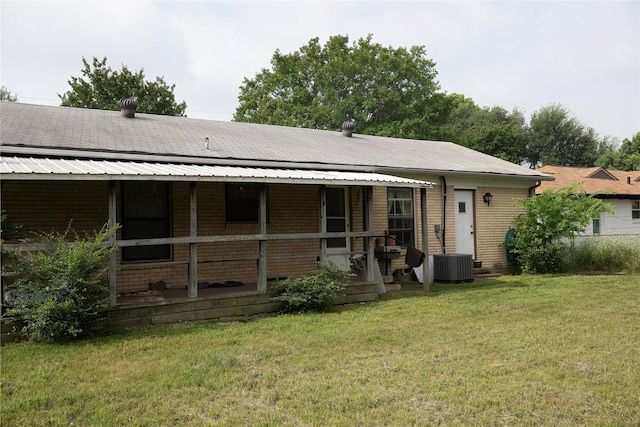 1219 Daisy Ln, Irving, TX 75061 - back of house featuring a lawn, covered porch, and central AC