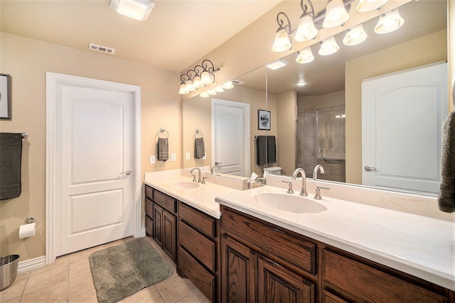 full bath featuring a tile shower, tile patterned floors, baseboards, and double vanity