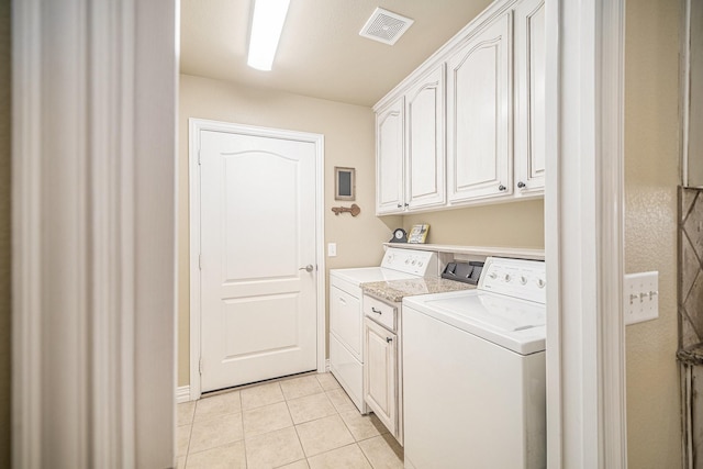 laundry area featuring cabinet space, washer and dryer, and light tile patterned floors