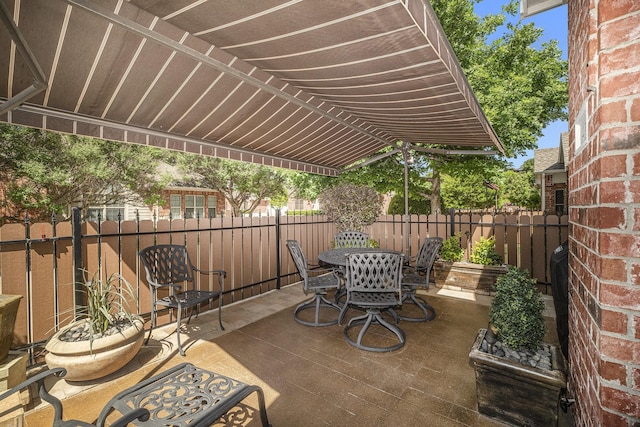 view of patio featuring fence and outdoor dining area