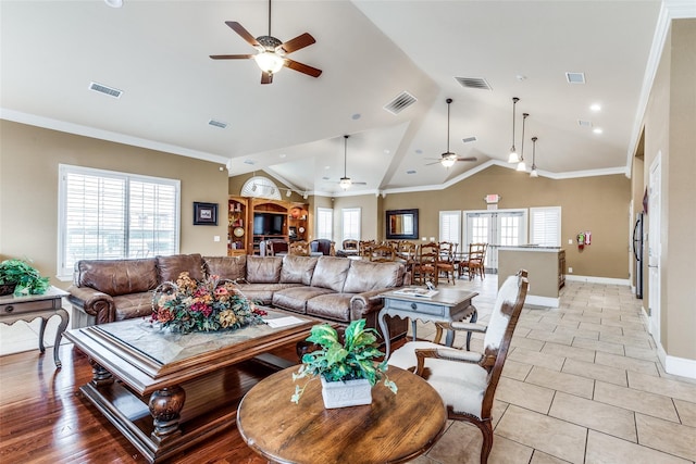 living area with a ceiling fan, lofted ceiling, baseboards, light tile patterned floors, and crown molding