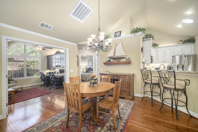 dining area featuring vaulted ceiling, an office area, ornamental molding, a chandelier, and wood finished floors