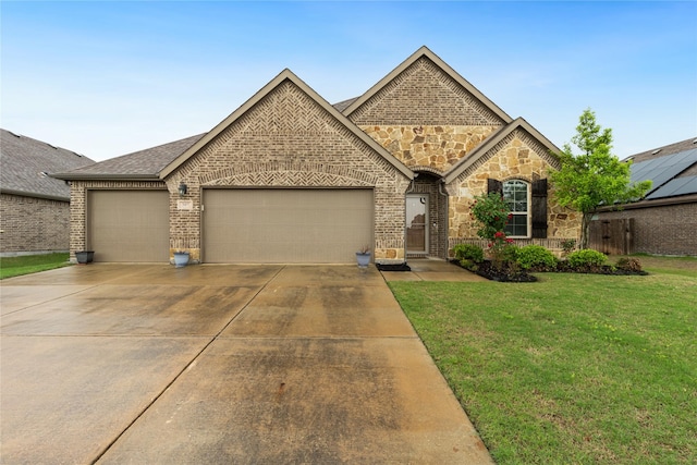 307 Acadia Ln, Forney, TX 75126 - french country style house featuring a garage, driveway, a front yard, stone siding, and brick siding