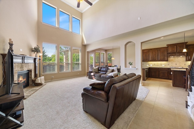 211 Crestbrook Dr, Rockwall, TX 75087 - living room with a brick fireplace, crown molding, a high ceiling, ceiling fan, and arched walkways