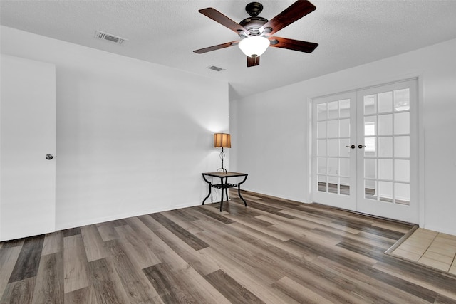 412 Lee Blvd, Pottsboro, TX 75076 - empty room with french doors, wood finished floors, a ceiling fan, and a textured ceiling