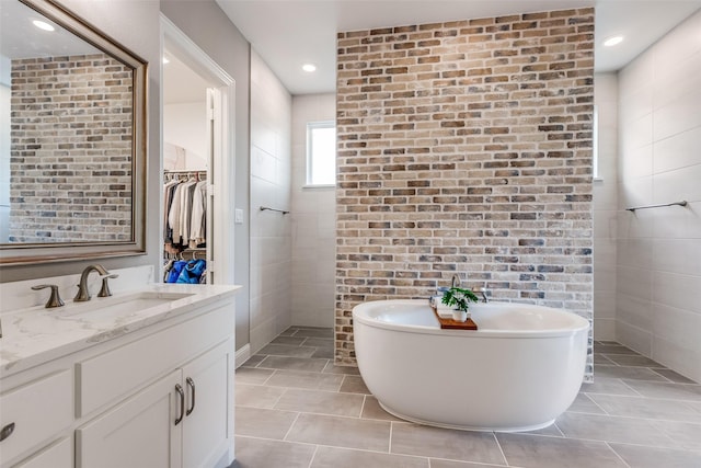8416 Shoreacres Dr, Mckinney, TX 75070 - bathroom featuring a freestanding bath, vanity, tile patterned floors, recessed lighting, and a walk in closet
