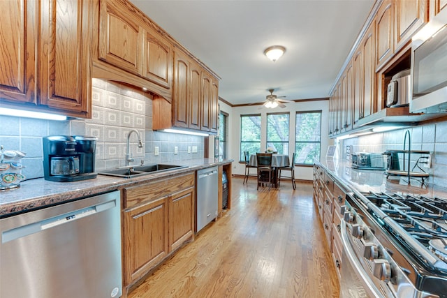 4402 Running Brook Dr, Rowlett, TX 75088 - kitchen with appliances with stainless steel finishes, a sink, a ceiling fan, tasteful backsplash, and light wood-type flooring