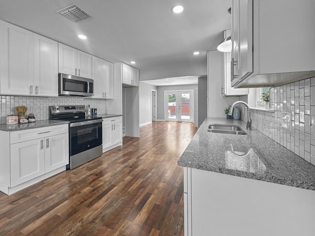 1209 N Morris St, Gainesville, TX 76240 - kitchen featuring stainless steel appliances, a sink, dark wood-style floors, backsplash, and recessed lighting