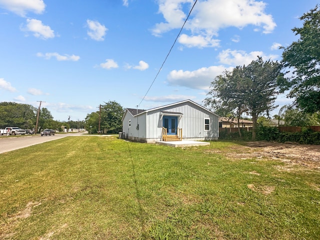 1209 N Morris St, Gainesville, TX 76240 - view of side of home with french doors, board and batten siding, and a lawn