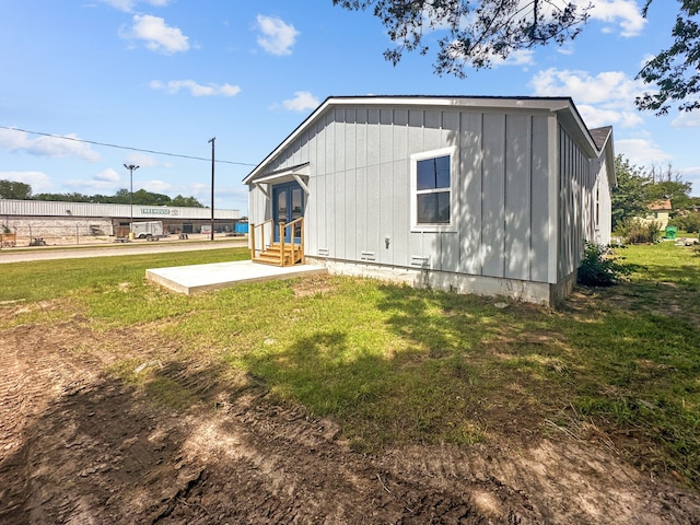 1209 N Morris St, Gainesville, TX 76240 - back of property featuring french doors, board and batten siding, a lawn, entry steps, and a patio area