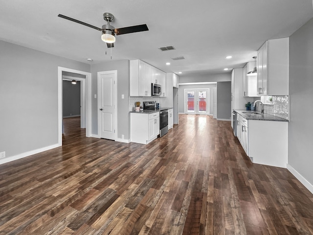 1209 N Morris St, Gainesville, TX 76240 - kitchen with appliances with stainless steel finishes, a sink, backsplash, ceiling fan, and dark wood-style flooring