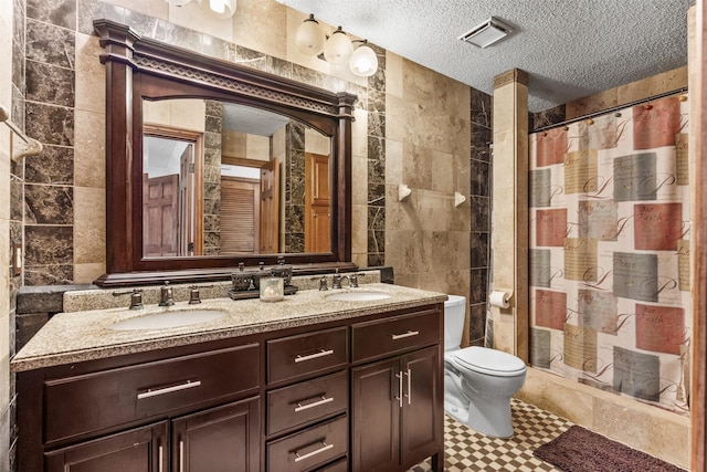 1104 Harwell Dr Unit 1514, Arlington, TX 76011 - bathroom featuring tile walls, a textured ceiling, double vanity, toilet, and a shower with curtain