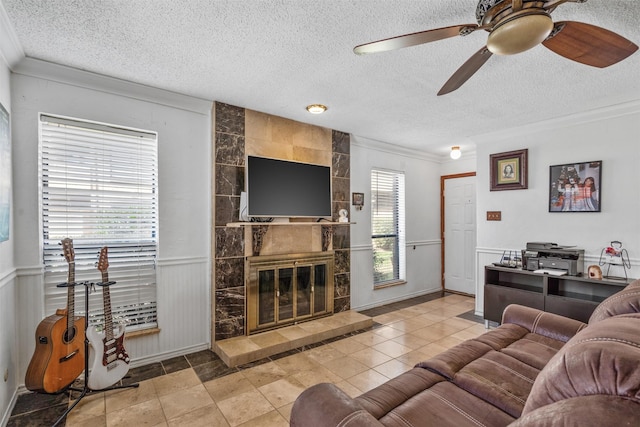 1104 Harwell Dr Unit 1514, Arlington, TX 76011 - living area with a textured ceiling, ornamental molding, a ceiling fan, wainscoting, and a tile fireplace