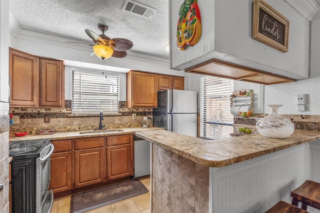 1104 Harwell Dr Unit 1514, Arlington, TX 76011 - kitchen featuring appliances with stainless steel finishes, a sink, a peninsula, backsplash, and a textured ceiling