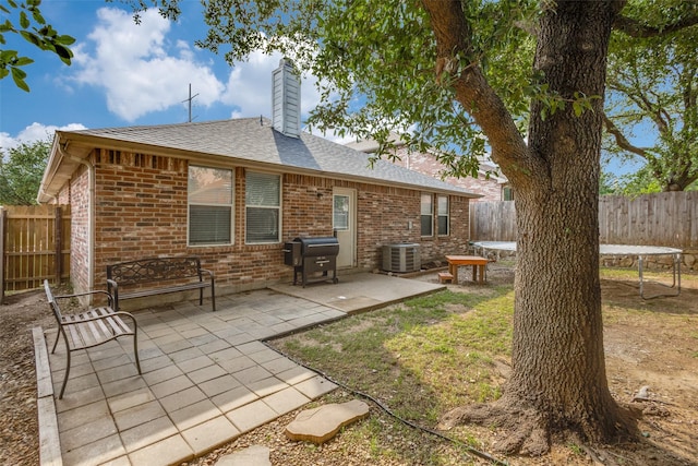 12748 Gillon Dr, Frisco, TX 75035 - back of property featuring a trampoline, brick siding, and a fenced backyard