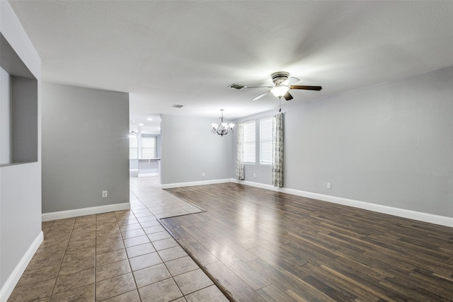 12748 Gillon Dr, Frisco, TX 75035 - spare room featuring a chandelier, a ceiling fan, baseboards, and wood finished floors