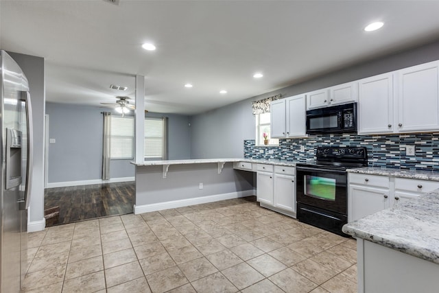 12748 Gillon Dr, Frisco, TX 75035 - kitchen featuring black appliances, decorative backsplash, white cabinetry, recessed lighting, and a peninsula