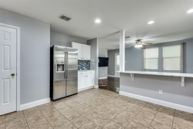 12748 Gillon Dr, Frisco, TX 75035 - kitchen with stainless steel refrigerator with ice dispenser, a ceiling fan, white cabinets, tasteful backsplash, and light stone countertops